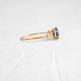 This engagement ring features 925 sterling silver with yellow gold plating, set with a deep blue round cut blue stone, exuding classic and noble elegance