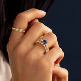 This engagement ring features 925 sterling silver with yellow gold plating, set with a deep blue round cut blue stone, exuding classic and noble elegance