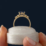 This engagement ring features 925 sterling silver with yellow gold plating, set with a deep blue round cut blue stone, exuding classic and noble elegance